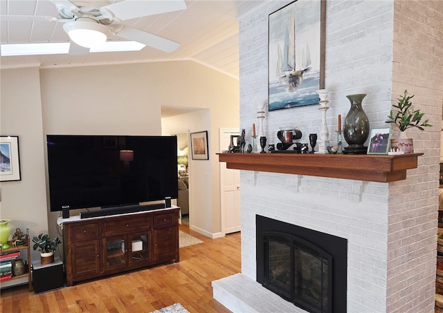 190 Broad Rock Rd, South Kingstown, RI 02879 - living area with lofted ceiling, a ceiling fan, light wood-type flooring, a brick fireplace, and baseboards
