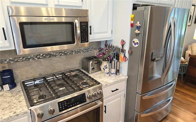 190 Broad Rock Rd, South Kingstown, RI 02879 - kitchen featuring stainless steel appliances, white cabinetry, tasteful backsplash, wood finished floors, and light stone counters