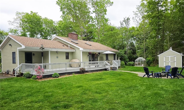 190 Broad Rock Rd, South Kingstown, RI 02879 - back of property featuring a fire pit, an exterior structure, a yard, a chimney, and covered porch