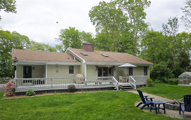 190 Broad Rock Rd, South Kingstown, RI 02879 - view of front of house with a fire pit, a greenhouse, a front yard, a chimney, and an outdoor structure