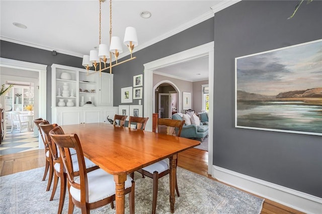 34 Dryden Ave, Pawtucket, RI 02860 - dining area featuring arched walkways, ornamental molding, wood finished floors, and a chandelier
