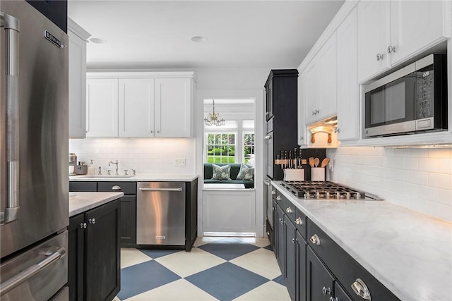 34 Dryden Ave, Pawtucket, RI 02860 - kitchen with stainless steel appliances, light floors, white cabinetry, dark cabinetry, and a sink