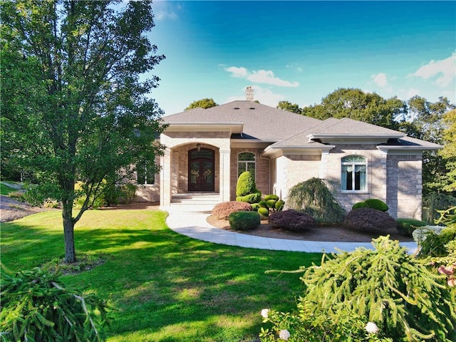 51 W Ridge Dr, Tiverton, RI 02878 - view of front facade featuring french doors, a front yard, a chimney, and brick siding