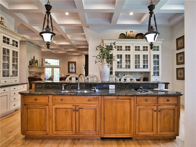 51 W Ridge Dr, Tiverton, RI 02878 - kitchen featuring a sink, coffered ceiling, light wood-type flooring, dark stone counters, and decorative light fixtures