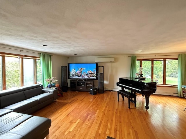 3945 Post Rd, Warwick, RI 02886 - living area with an AC wall unit, light wood-type flooring, and a baseboard heating unit