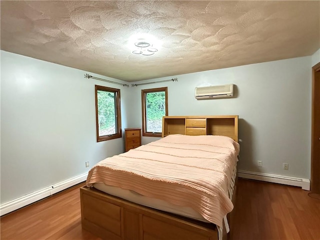 3945 Post Rd, Warwick, RI 02886 - bedroom featuring a baseboard radiator, a wall mounted AC, baseboards, dark wood-style flooring, and a textured ceiling