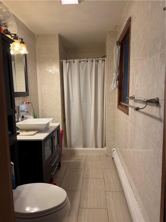 3945 Post Rd, Warwick, RI 02886 - full bath with tile walls, vanity, a stall shower, toilet, and tile patterned flooring