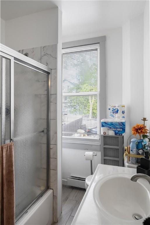 15 Ruggles St, Providence, RI 02908 - full bathroom featuring baseboard heating, toilet, shower / bath combination with glass door, and vanity