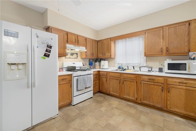 22 Myrtle St, Pawtucket, RI 02860 - kitchen with white appliances, under cabinet range hood, light countertops, and brown cabinets
