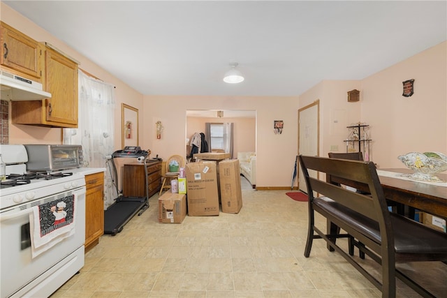 22 Myrtle St, Pawtucket, RI 02860 - kitchen with white range with gas stovetop, under cabinet range hood, and light countertops
