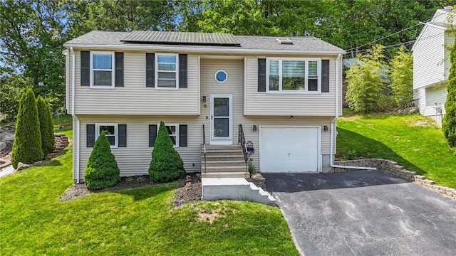 15 Lawnacre Dr, North Providence, RI 02911 - raised ranch featuring a front yard, asphalt driveway, solar panels, and an attached garage
