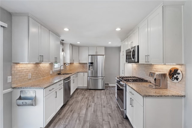 23 Revere St, Pawtucket, RI 02861 - kitchen featuring stainless steel appliances, a sink, light wood-style flooring, tasteful backsplash, and recessed lighting