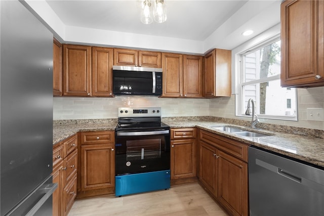 123 Forestwood Dr, North Providence, RI 02904 - kitchen with stainless steel appliances, a sink, brown cabinets, and light stone countertops
