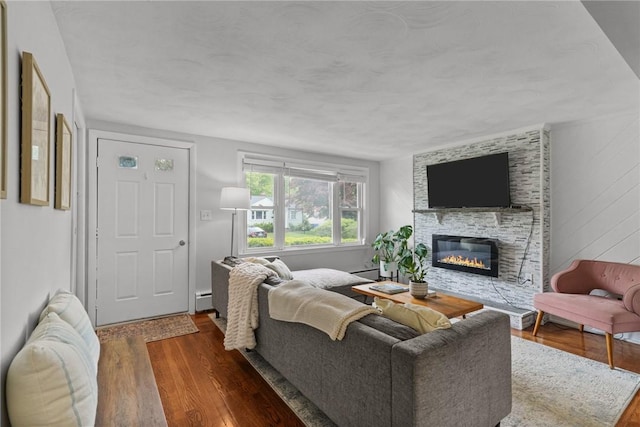156 Davis Ave, Cranston, RI 02910 - living area with wood finished floors, a stone fireplace, and baseboard heating
