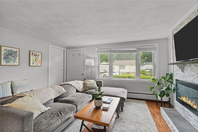 156 Davis Ave, Cranston, RI 02910 - living area with wood finished floors, a stone fireplace, and baseboard heating