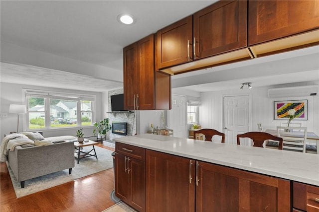 156 Davis Ave, Cranston, RI 02910 - kitchen with open floor plan, light countertops, a stone fireplace, light wood-style floors, and a wall mounted AC
