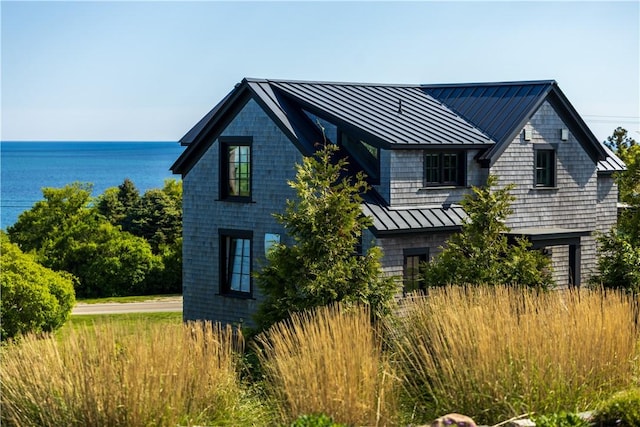 1448 Mohegan Trl, Block Island, RI 02807 - view of side of property with a standing seam roof, metal roof, and a water view