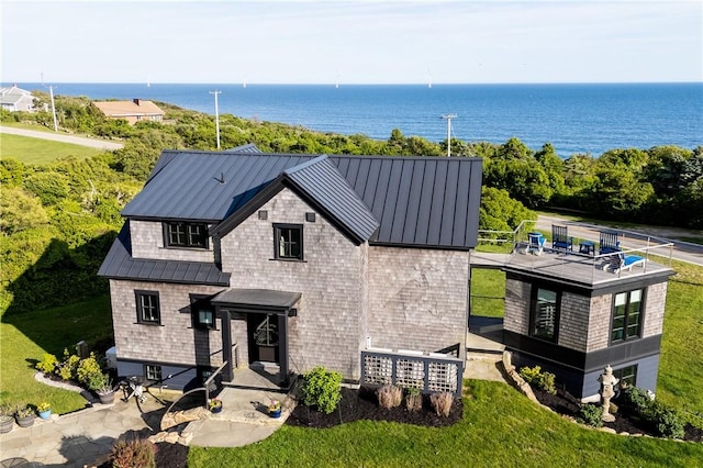 1448 Mohegan Trl, Block Island, RI 02807 - view of front of property featuring a standing seam roof, a water view, metal roof, and a front lawn