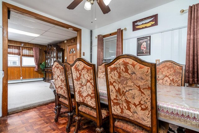 85 Herschel St, Providence, RI 02909 - dining area featuring baseboard heating, ceiling fan, wood walls, and a drop ceiling
