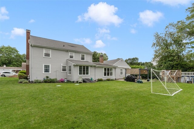 15 Metcalf Dr, Cumberland, RI 02864 - back of house with a chimney and a lawn