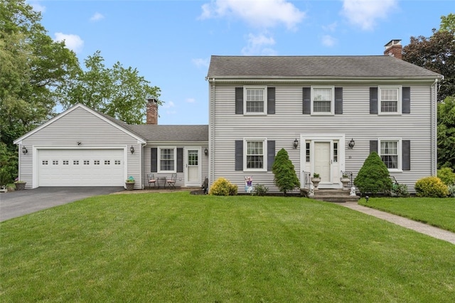 15 Metcalf Dr, Cumberland, RI 02864 - colonial-style house featuring a chimney, driveway, a garage, a front lawn, and roof with shingles