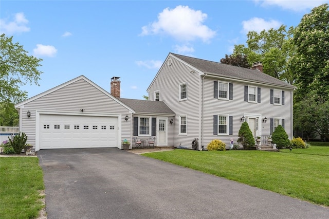 15 Metcalf Dr, Cumberland, RI 02864 - colonial inspired home with a chimney, asphalt driveway, an attached garage, a front lawn, and a shingled roof