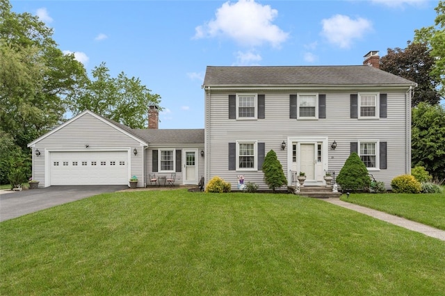 15 Metcalf Dr, Cumberland, RI 02864 - colonial home featuring a chimney, asphalt driveway, a front yard, and a garage