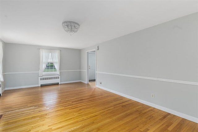 15 Metcalf Dr, Cumberland, RI 02864 - unfurnished room with radiator, light wood-type flooring, and a chandelier