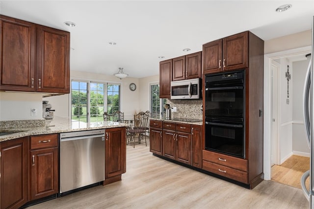 15 Metcalf Dr, Cumberland, RI 02864 - kitchen featuring black appliances, light wood-style floors, decorative backsplash, light stone countertops, and dark brown cabinets