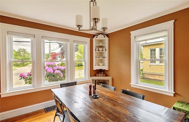 796 Pontiac Ave, Cranston, RI 02910 - dining room featuring plenty of natural light, baseboards, light wood-type flooring, and ornamental molding