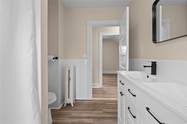 62 Fenner Ave, East Providence, RI 02915 - full bath featuring radiator heating unit, wood finished floors, double vanity, toilet, and tile walls
