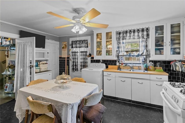 43 Dexter St, Woonsocket, RI 02895 - kitchen featuring a sink, washer / clothes dryer, white appliances, white cabinetry, and crown molding