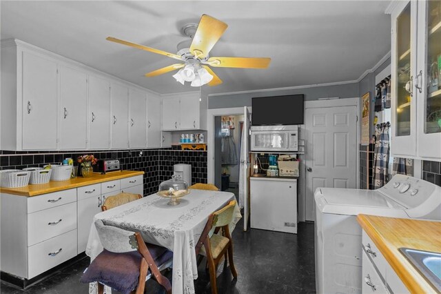 43 Dexter St, Woonsocket, RI 02895 - kitchen with washing machine and clothes dryer, white cabinets, white microwave, and crown molding