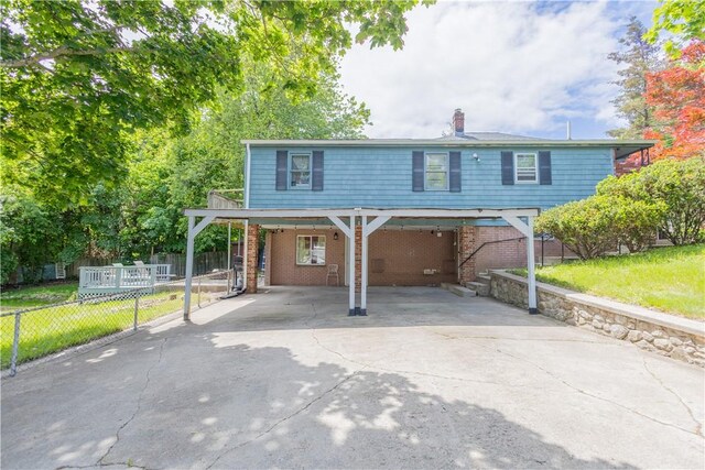 79 George Waterman Rd, Johnston, RI 02919 - traditional-style home with a carport, driveway, a chimney, and brick siding