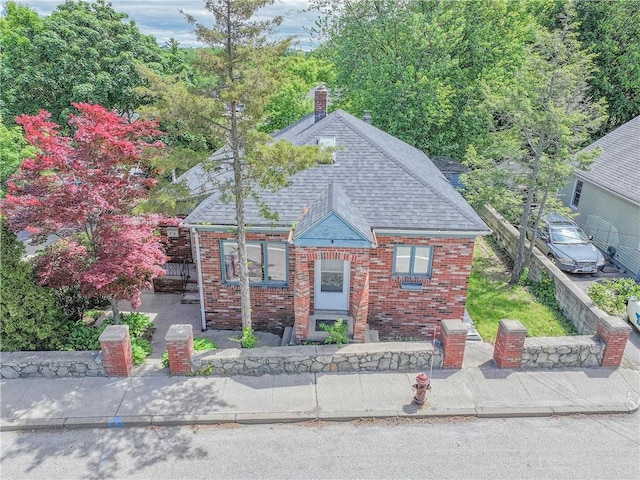 79 George Waterman Rd, Johnston, RI 02919 - view of front of home with brick siding, a chimney, roof with shingles, and a patio area