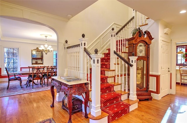 45 Burns Way E, Greenwich, RI 02818 - staircase featuring crown molding, healthy amount of natural light, wood finished floors, a chandelier, and arched walkways