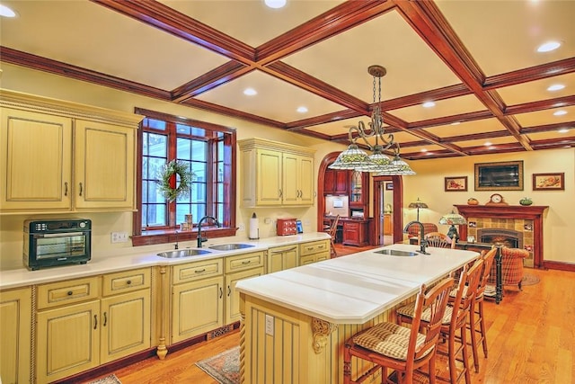 45 Burns Way E, Greenwich, RI 02818 - kitchen with a sink, light countertops, a center island with sink, coffered ceiling, and light wood finished floors
