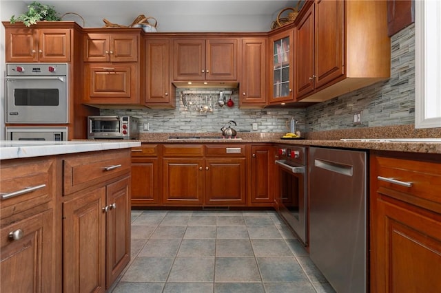 95 Pheasant Dr, East Greenwich, RI 02818 - kitchen with appliances with stainless steel finishes, brown cabinetry, and tasteful backsplash