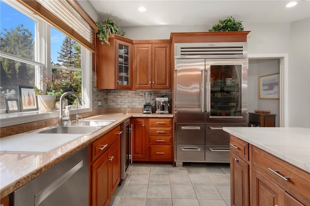 95 Pheasant Dr, East Greenwich, RI 02818 - kitchen featuring appliances with stainless steel finishes, a sink, light tile patterned floors, brown cabinetry, and recessed lighting