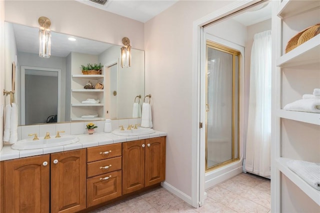95 Pheasant Dr, East Greenwich, RI 02818 - bathroom with double vanity, a shower with shower door, baseboards, and tile patterned floors