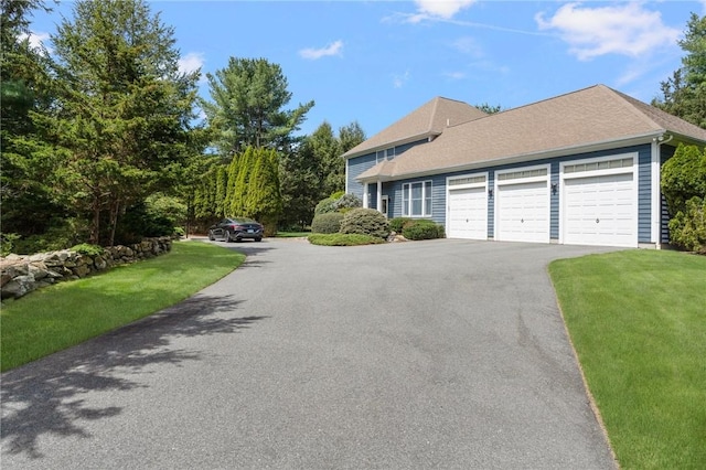 95 Pheasant Dr, East Greenwich, RI 02818 - view of front of house featuring asphalt driveway, a garage, and a front lawn