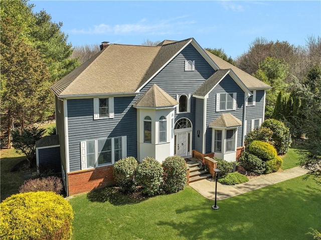 95 Pheasant Dr, East Greenwich, RI 02818 - view of front facade with a front lawn, brick siding, a shingled roof, and a chimney