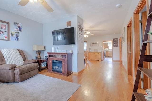 254 Jenckes St, Woonsocket, RI 02895 - living area with a ceiling fan, light wood-type flooring, a glass covered fireplace, and baseboards