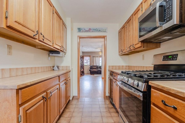 254 Jenckes St, Woonsocket, RI 02895 - kitchen featuring stainless steel appliances, light countertops, and light tile patterned floors
