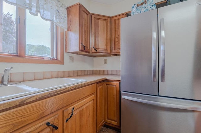 254 Jenckes St, Woonsocket, RI 02895 - kitchen with freestanding refrigerator, light countertops, brown cabinetry, and a sink