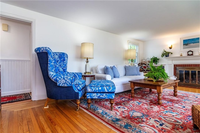 170 Pilgrim Pkwy, Warwick, RI 02888 - living room with wood finished floors, a brick fireplace, and a wainscoted wall
