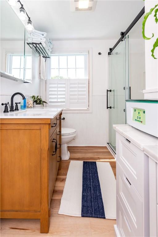 170 Pilgrim Pkwy, Warwick, RI 02888 - bathroom with vanity, a shower stall, toilet, and wood finished floors