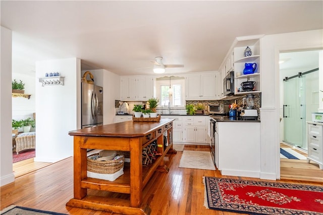 170 Pilgrim Pkwy, Warwick, RI 02888 - kitchen featuring stainless steel appliances, dark countertops, white cabinetry, a ceiling fan, and open shelves