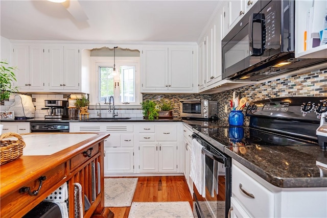 170 Pilgrim Pkwy, Warwick, RI 02888 - kitchen with black appliances, a sink, light wood finished floors, white cabinetry, and tasteful backsplash