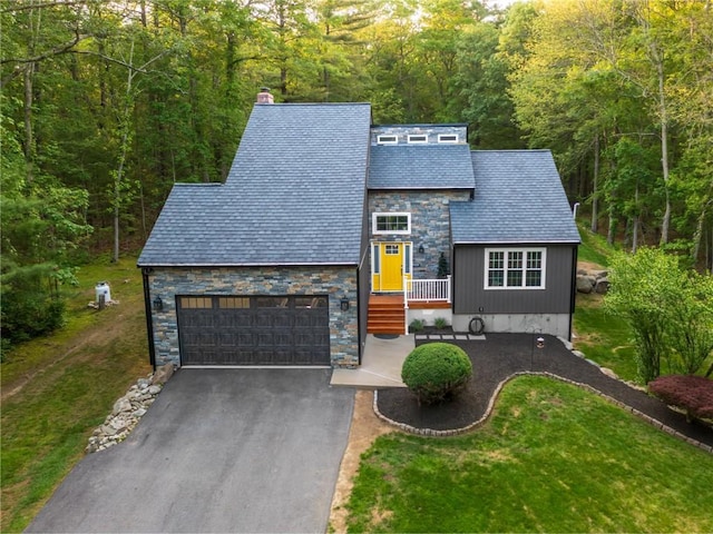 511 Central Pike, Scituate, RI 02857 - view of front of home with stone siding, a wooded view, asphalt driveway, a front lawn, and a high end roof